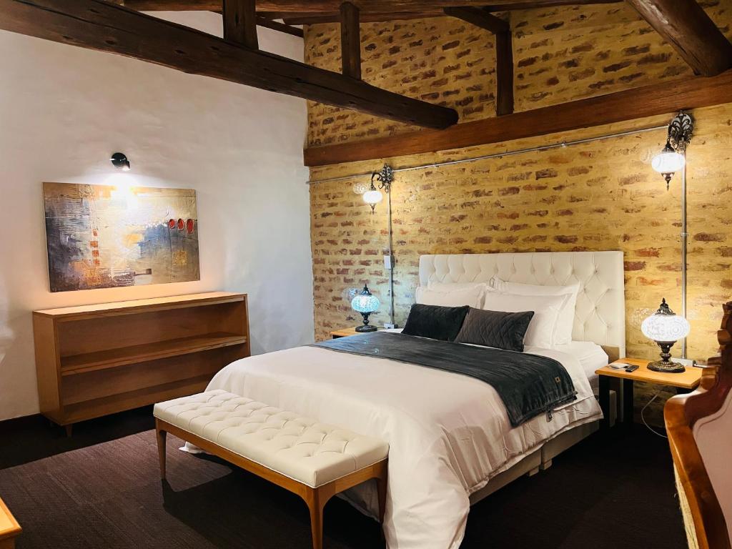 a bedroom with a white bed and a wooden wall at Hotel Caney Villa de Leyva by MH in Villa de Leyva