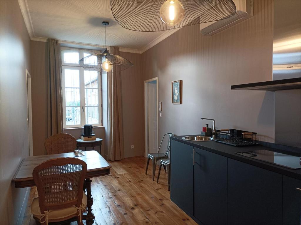 a kitchen and dining room with a table and chairs at LA MAISON DU SOLEIL in LʼIsle-Jourdain
