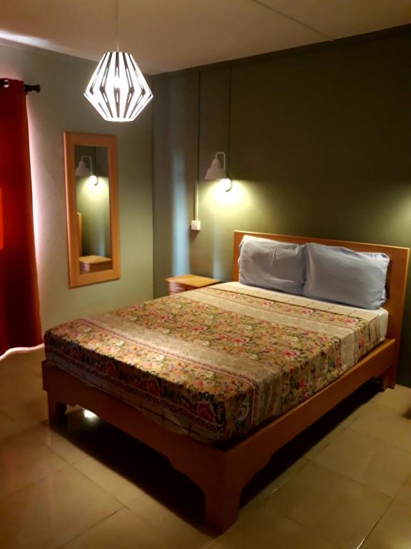 1 dormitorio con cama y lámpara de araña en Lux - Palace Apartment Trou Aux Biches en Trou aux Biches