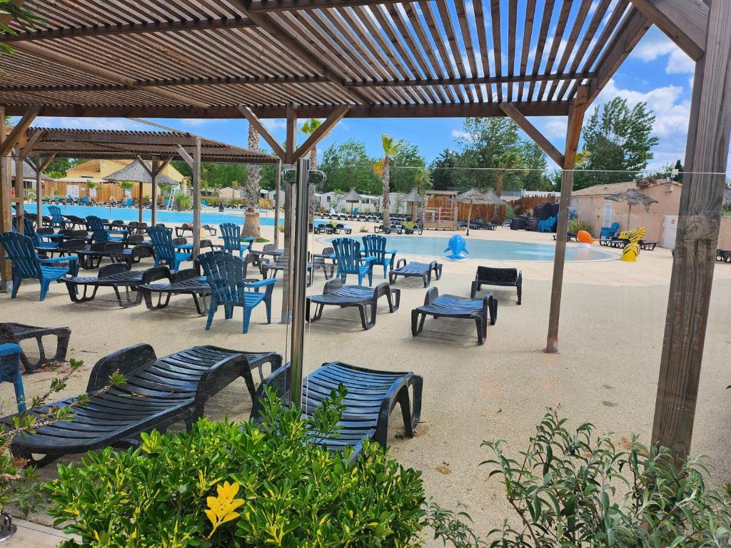 a group of chairs and tables in front of a pool at camping sable du midi 4 etoile in Valras-Plage
