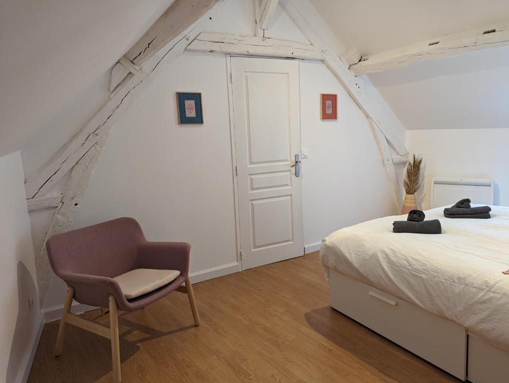 a bedroom with a bed and a chair in it at Duplex de 65 m2, Cœur de Bonneval in Bonneval