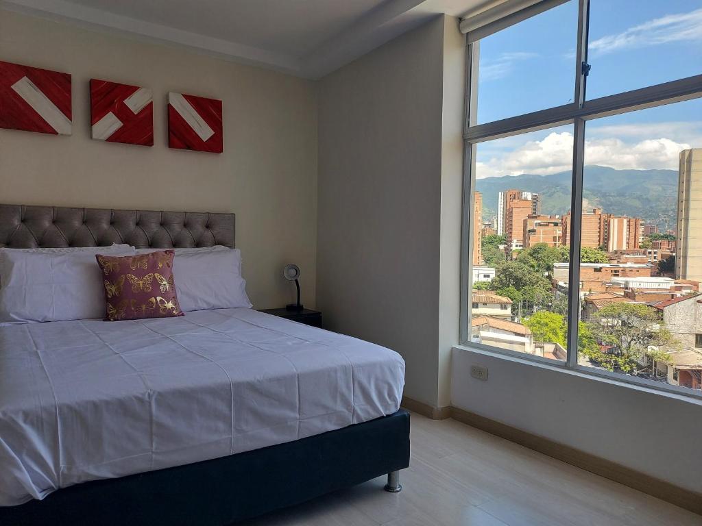 1 dormitorio con cama y ventana grande en San Peter Apartments, en Medellín