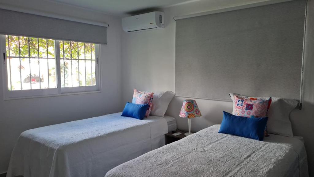 ein Zimmer mit zwei Betten und einem Fenster in der Unterkunft Villa Lol-Ha in Cancún