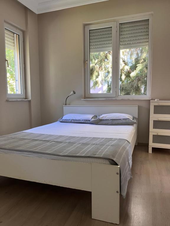 1 dormitorio con 1 cama grande y 2 ventanas en Room in the Peaceful Duplex-Lara2, en Antalya