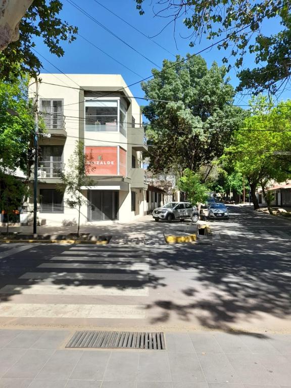 eine Straße mit einem Gebäude und Bäumen an der Seite in der Unterkunft La casa de kiki Departamento excelente ubicación in Godoy Cruz