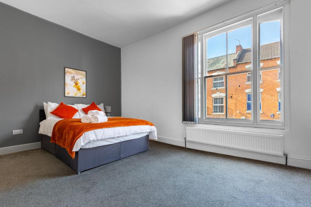 a bedroom with a bed and a large window at Palatial Six Bedroom Haven in Northampton