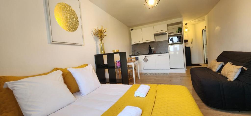 Una sala de estar con un sofá y una cocina. en Le Bellecroix, en Metz
