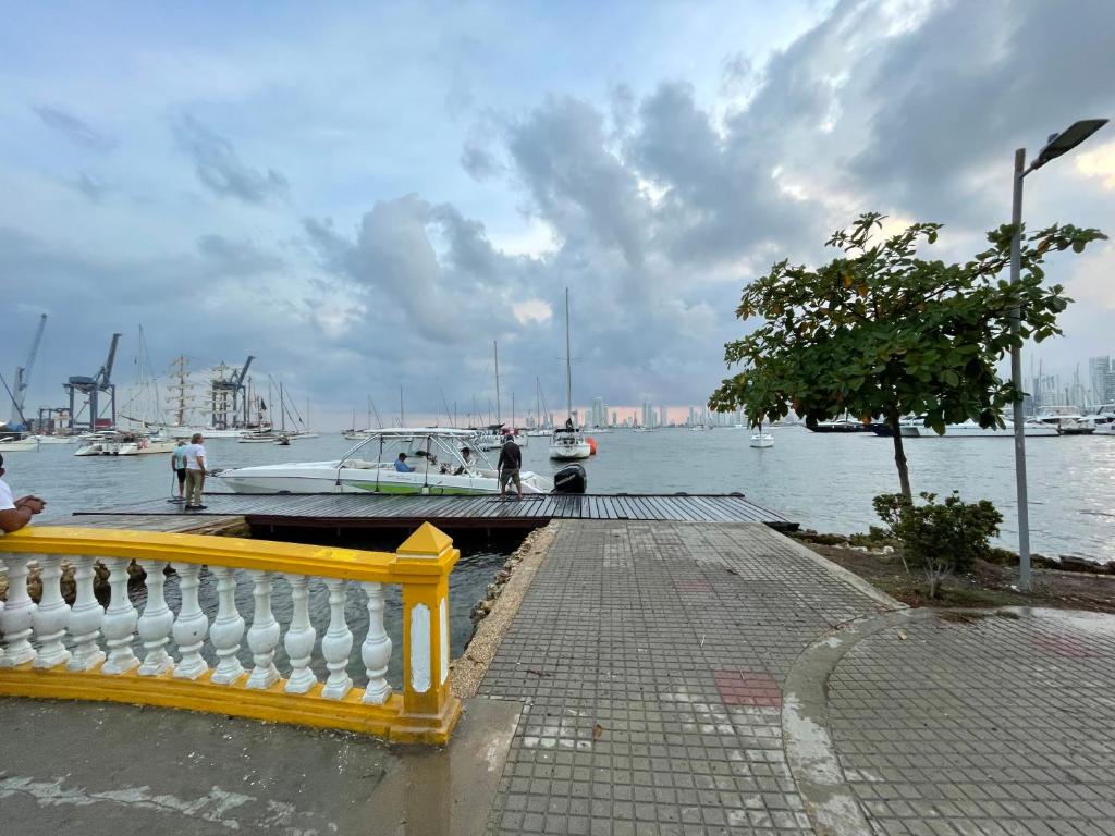 żółty płot obok przystani z łodziami w wodzie w obiekcie Villa Magaly Manga - Centro Histórico w mieście Cartagena de Indias