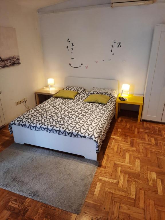 a bedroom with a bed with two yellow pillows at Studio apartment in Zagreb