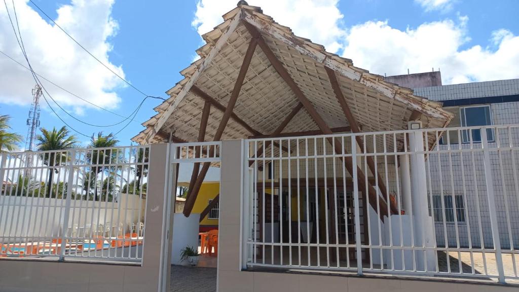 a white gate with a roof on top of a building at Pousada leblon in Caucaia