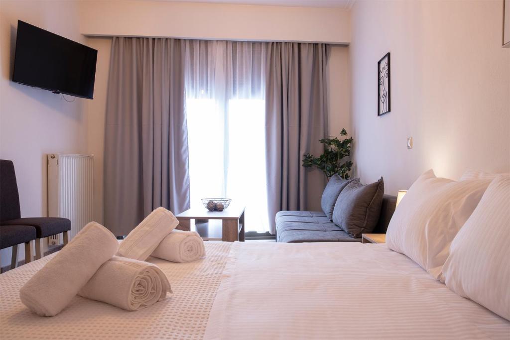 a hotel room with a large white bed and a couch at Olymp-rooms in Litochoro