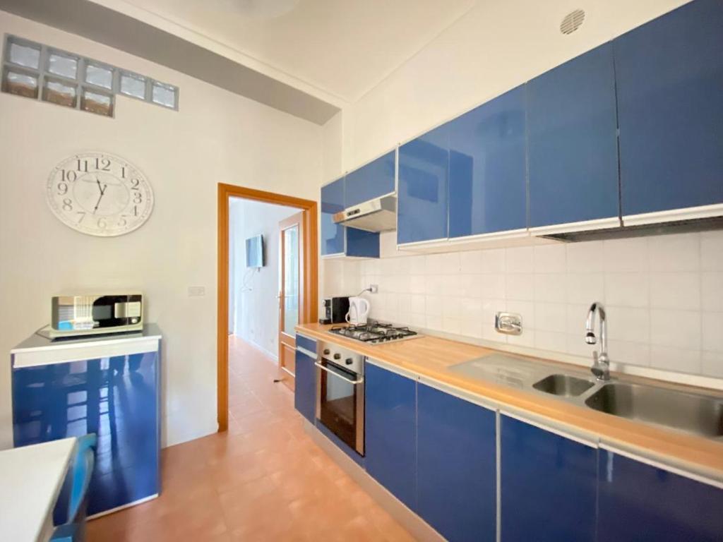 a kitchen with blue cabinets and a clock on the wall at TurinHouse in Turin