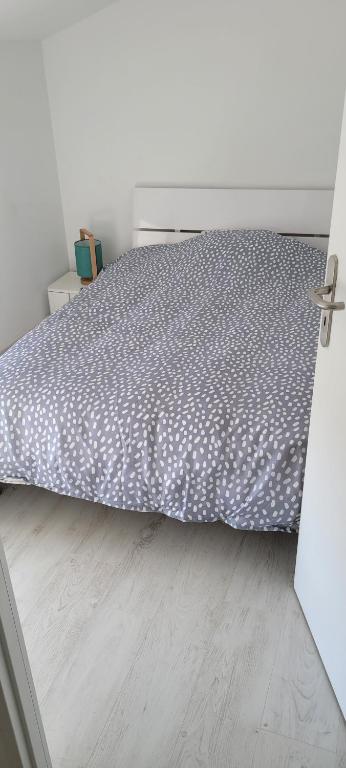 um quarto com uma cama e piso em madeira em Appartement 15km Futuroscope em Saint-Julien-lʼArs