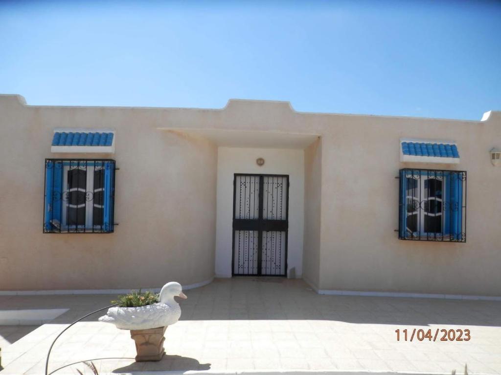 une maison blanche avec un oiseau devant dans l'établissement Villa Amine MG, à Fafou