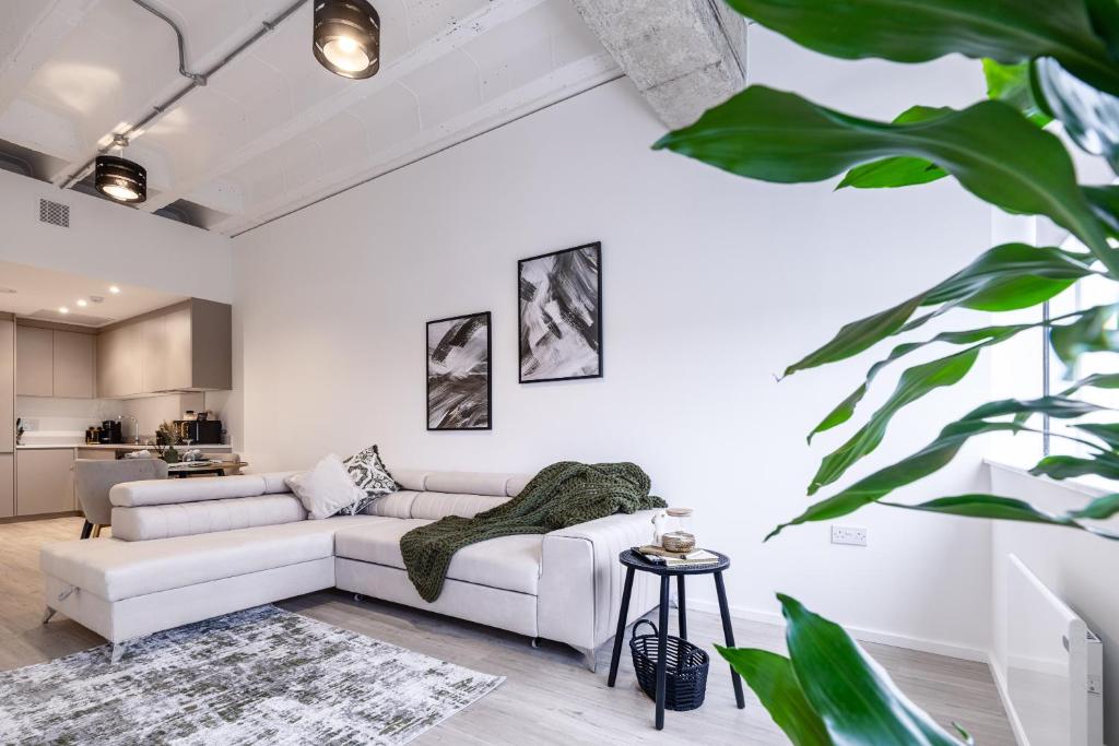 a living room with a white couch and a table at Station House in Milton Keynes