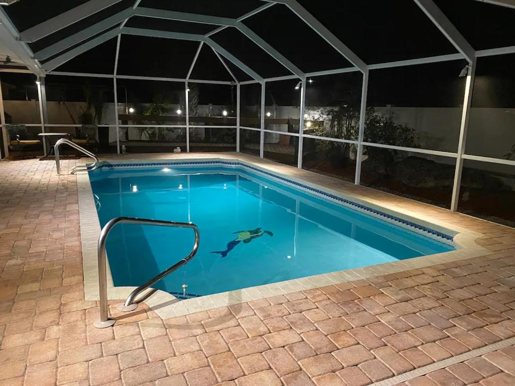 a swimming pool at night with a tent at Venice villa with heated pool, lanai, near beach in Venice