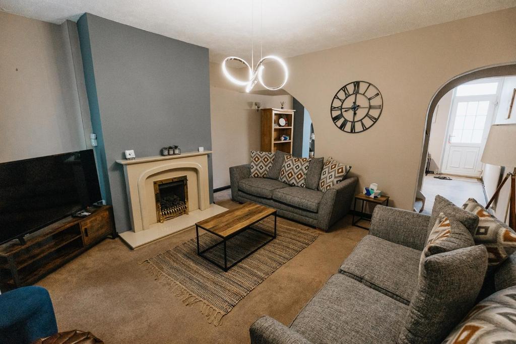 un soggiorno con divano e camino di Winnie's Cottage - 3 Bed Accommodation in Cumbria a Mealsgate