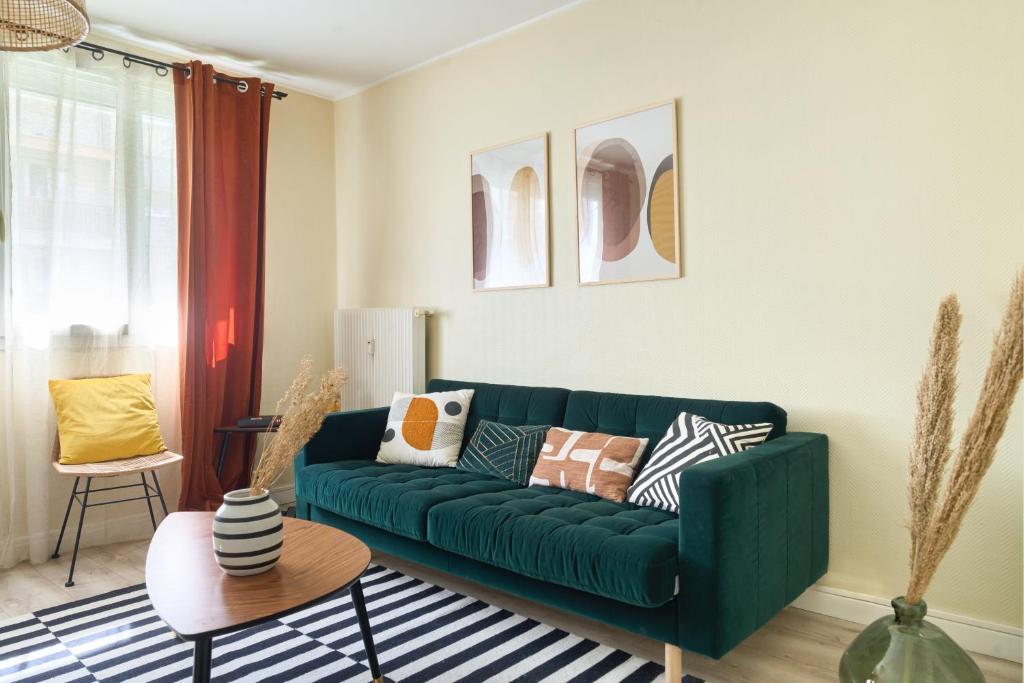 a living room with a green couch at appartement cosy et charme au coeur de Besancon in Besançon