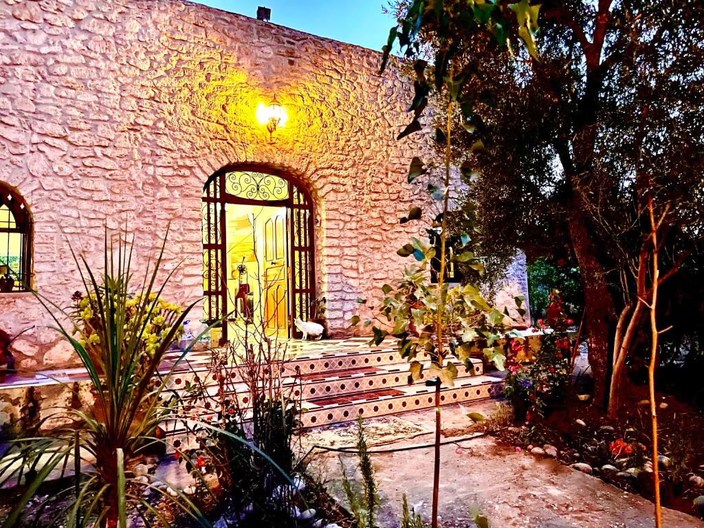 OunaraにあるBelle villa privéのレンガ造りの建物(ドア付)と植物のある中庭