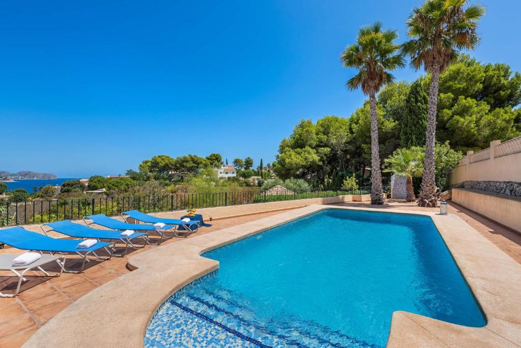 a swimming pool with lounge chairs and a swimming pool at Villa Rodrigo - PlusHolidays in Benissa