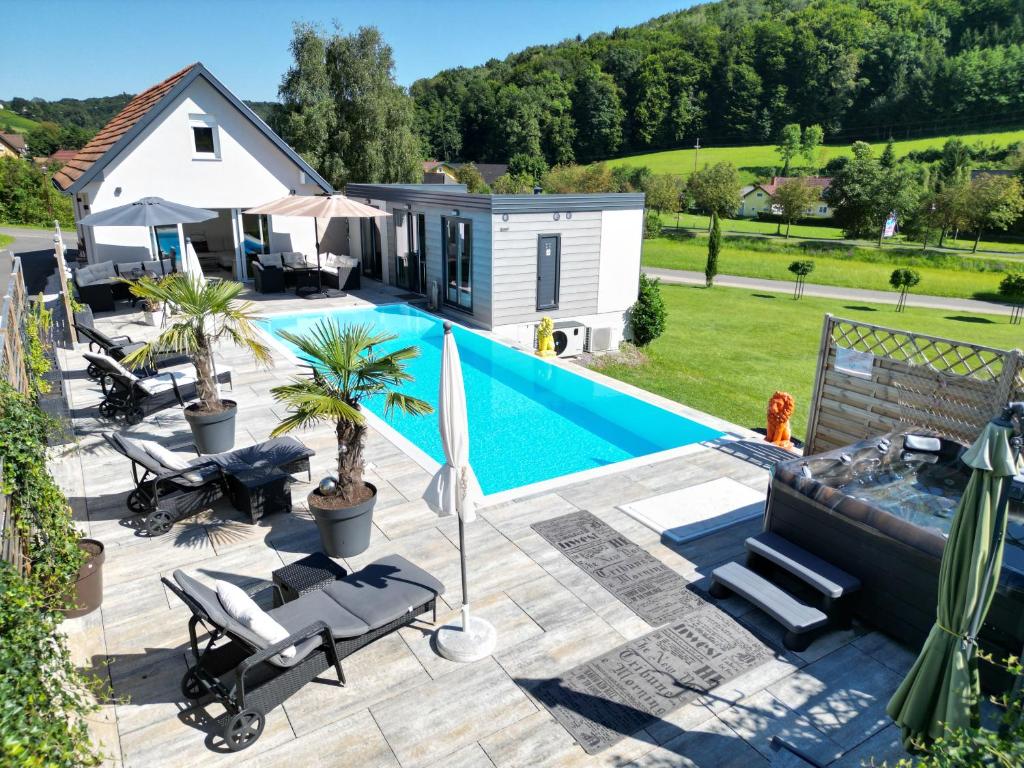 a backyard with a swimming pool and a tiny house at Feriendomizil Schleich im Thermenland in Bad Gleichenberg