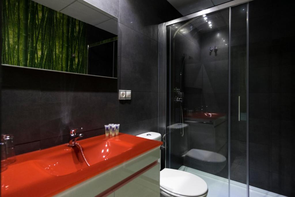 bagno con lavandino rosso e servizi igienici di CASA CON PATIO a Pozoblanco