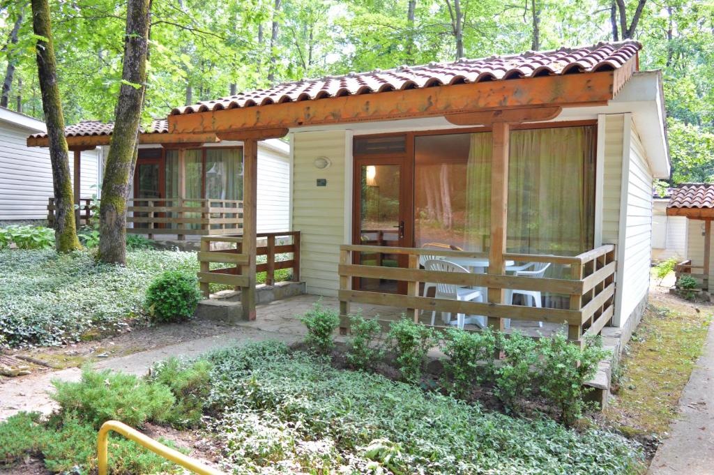 een kleine hut in het bos met een veranda bij Villas Holidays in Primorsko