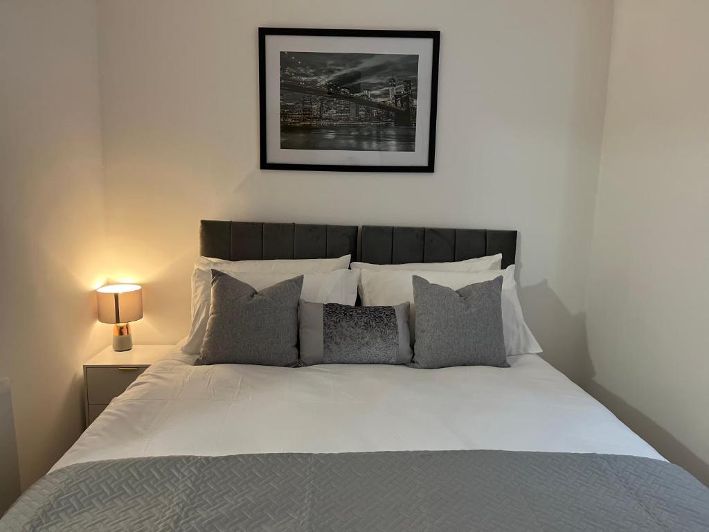Una cama con sábanas blancas y almohadas en un dormitorio en Beautiful Apartment & Parking en York