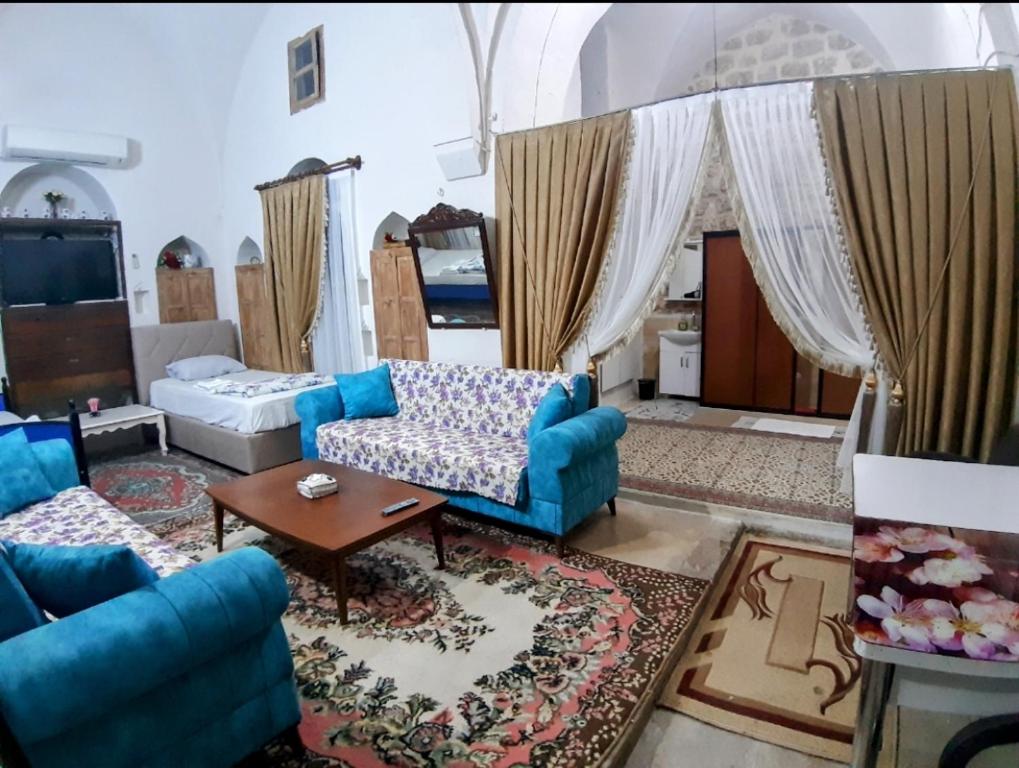 ein Wohnzimmer mit einem blauen Sofa und einem Tisch in der Unterkunft Aydınbey konagı in Mardin