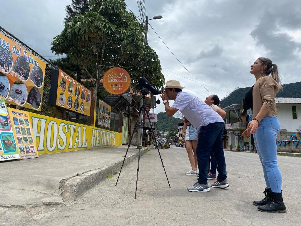 a woman taking a picture of a man with a camera at Hostal Henrry's in Mindo