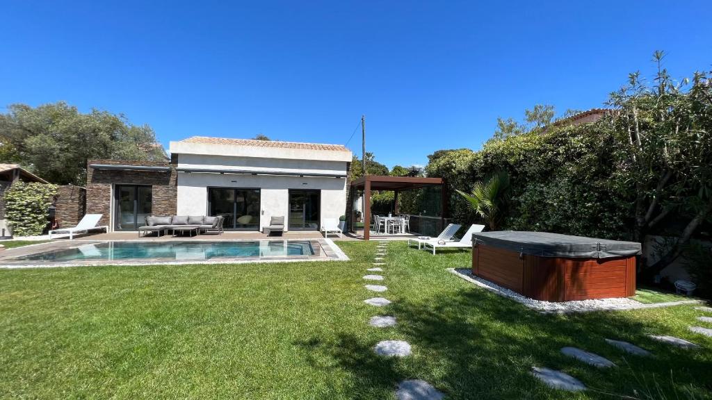 une cour arrière avec une piscine et une maison dans l'établissement Capleouna-Villa la Cabane, à Antibes
