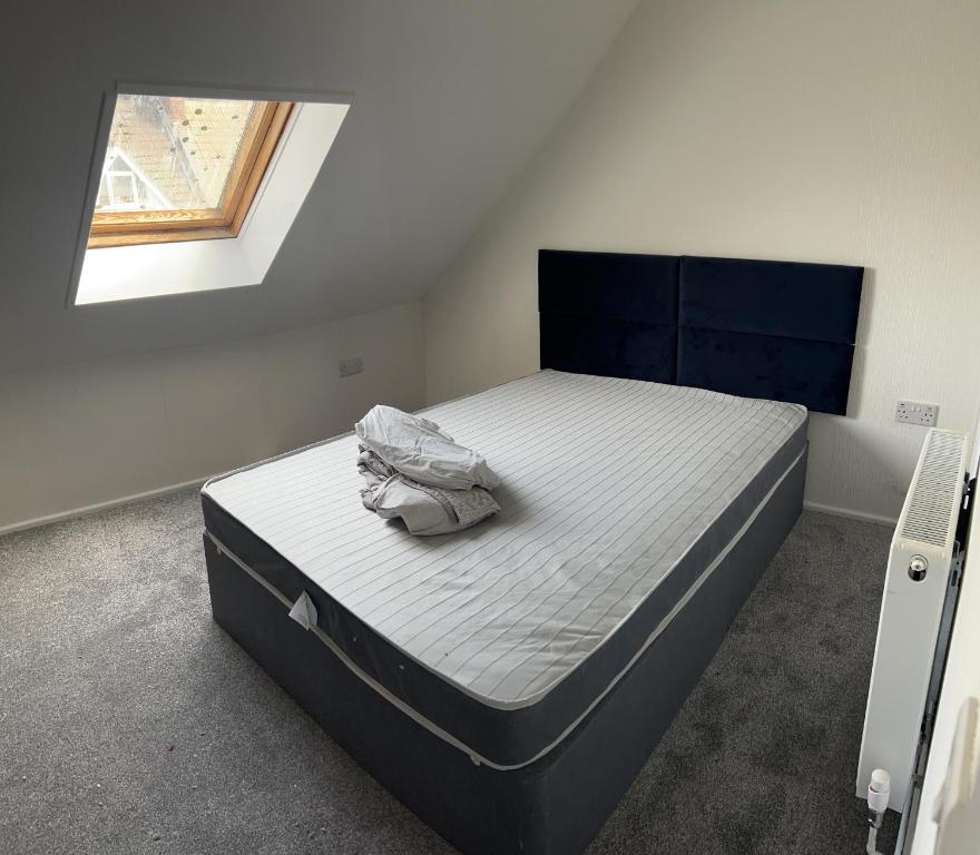 um quarto com uma cama num quarto com uma janela em Excellent 3bed flat em Kent