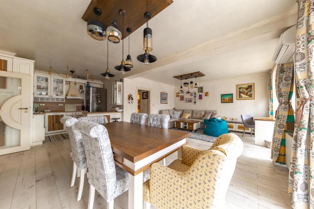 kuchnia i jadalnia z drewnianym stołem i krzesłami w obiekcie Happy Town Apartments w mieście Wielkie Tyrnowo