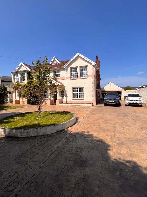 a house with two cars parked in a driveway at Family & friends get together birthday hot tub in Porthcawl