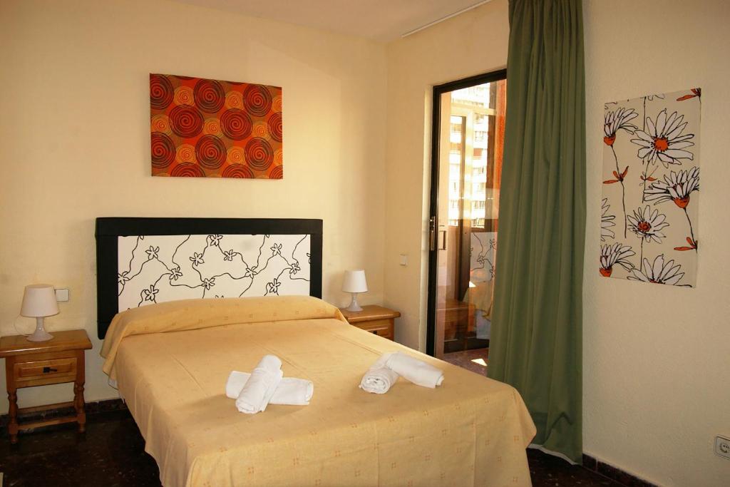 a bedroom with a bed with two towels on it at Apartamentos Torre Don Vicente - Arca Rent in Benidorm