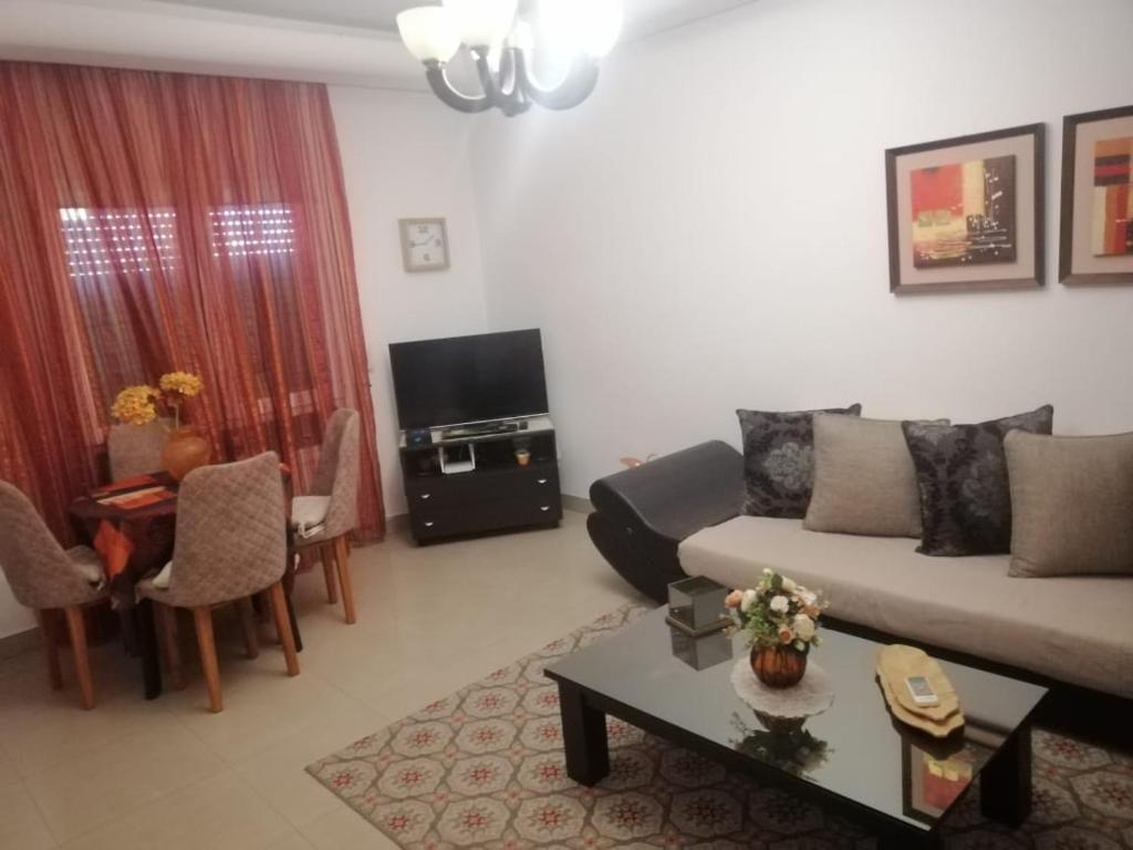 ein Wohnzimmer mit einem Sofa und einem Tisch in der Unterkunft Appartement - Manar 1 Tunis in Tunis