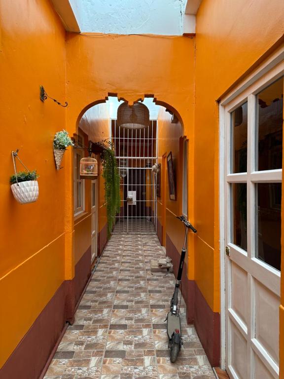 una pared naranja con una moto estacionada en un pasillo en Amalfi's Place, en Pimentel