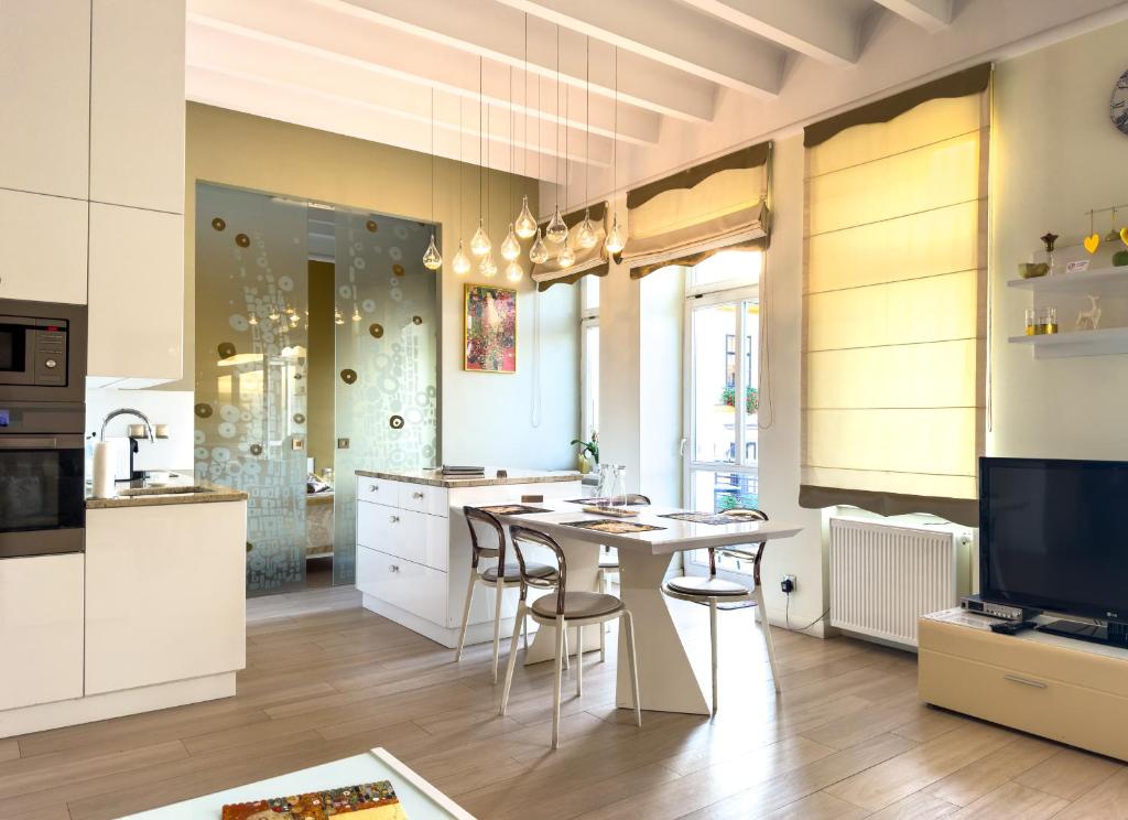 a kitchen with a table and chairs and a television at Apartament Cesarski in Cieszyn