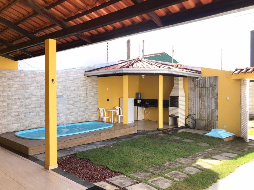 a house with a swimming pool in a backyard at Casa Amarela na Praia de Guaibim-Taquari in Guaibim