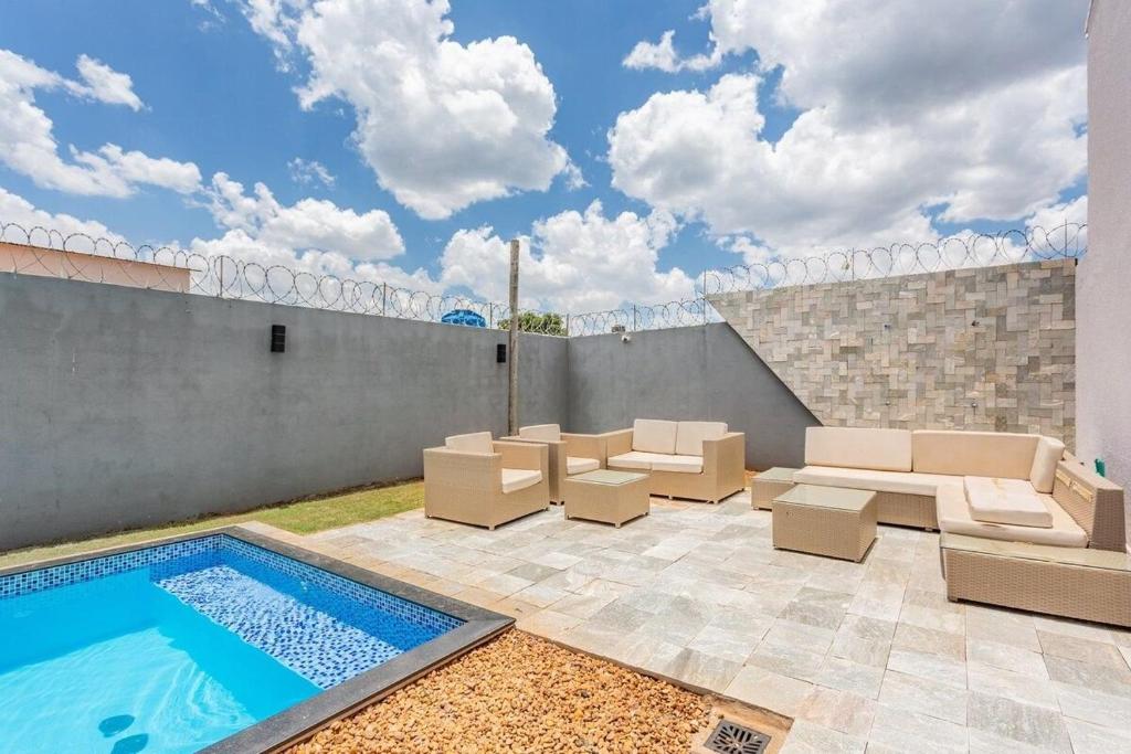 a patio with chairs and a swimming pool at Requinte, conforto e privacidade in Pirenópolis