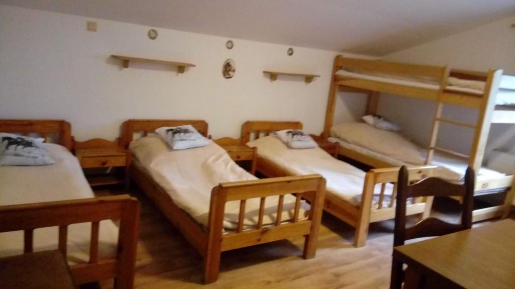 Zimmer mit 3 Etagenbetten und einem Tisch in der Unterkunft AGRODEO Gospodarstwo Agroturystyczne in Gąsawa
