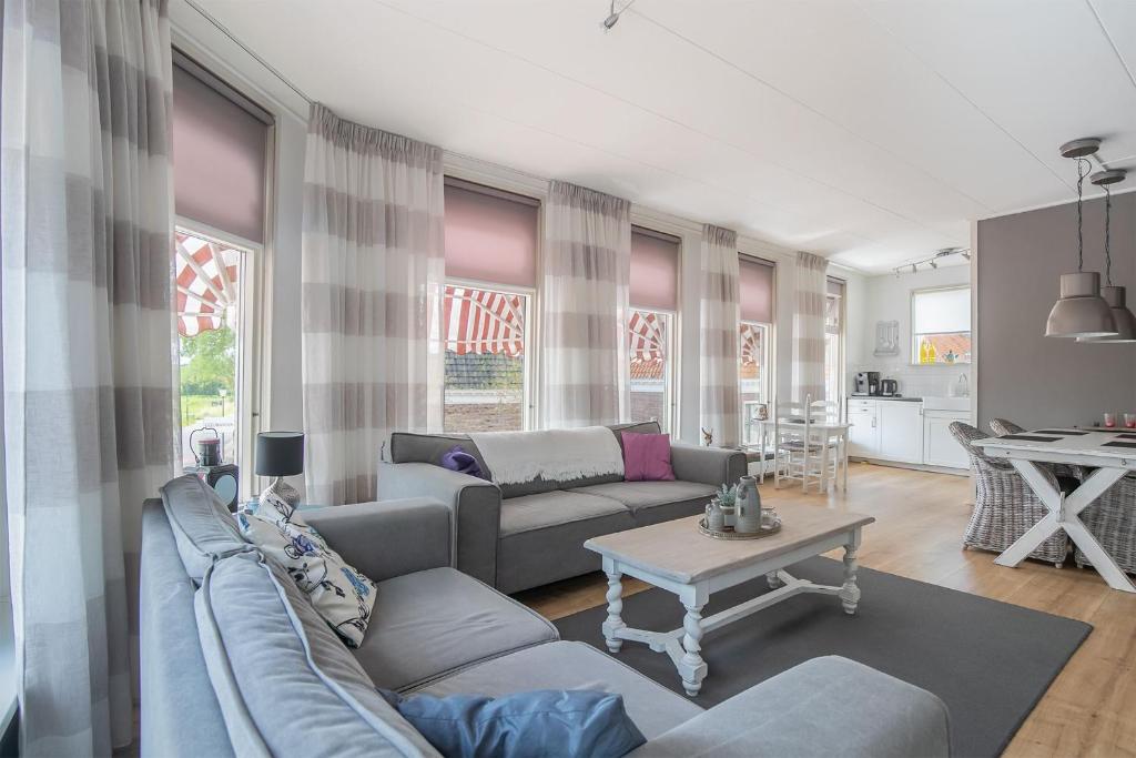 a living room with a couch and a table at Appartement De Boppeslach in Marssum