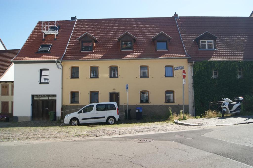 una furgoneta blanca estacionada frente a un edificio en Saarlogis Haus Ferienwohnungen St Arnual en Saarbrücken