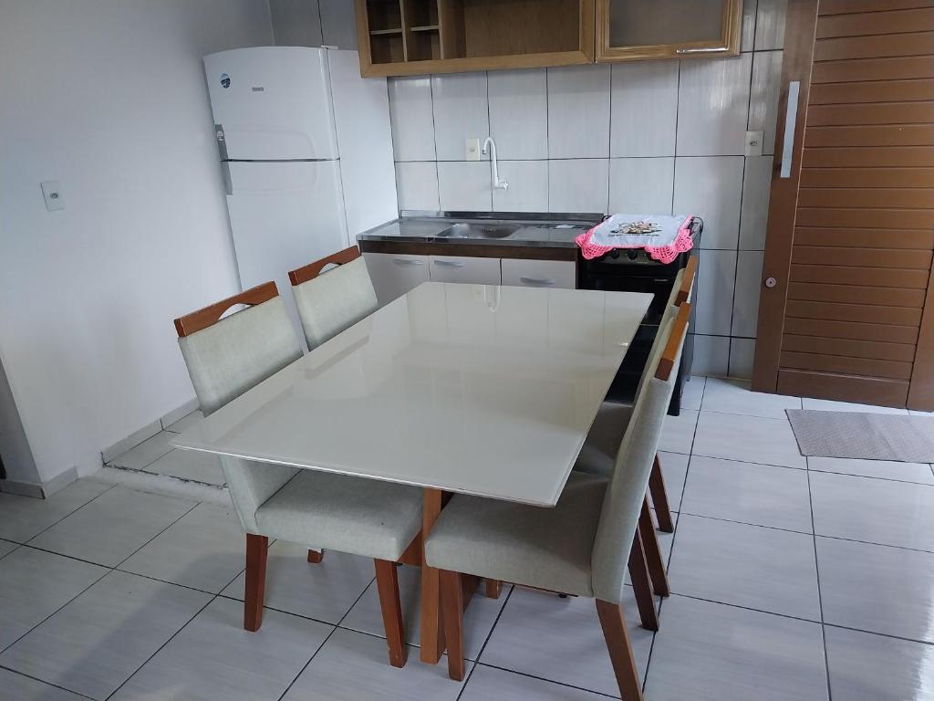 una mesa blanca y sillas en una cocina en Aluguel temporada- Praia en Governador Celso Ramos