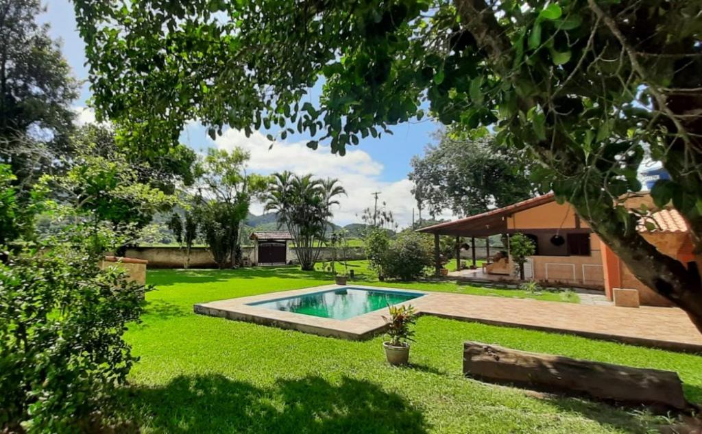 een achtertuin met een zwembad in het gras bij Sítio Vivendo & Aprendendo in Tanguá