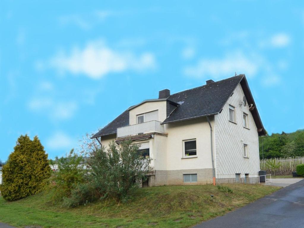 a white house with a black roof at Apartment on the Moselle in Neumagen Dhron in Neumagen-Dhron