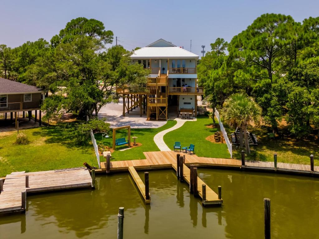 a house with a dock next to a body of water at Island Soul Waterlemon Cay Villa - Unit 1 - 500 Lemoyne condo in Dauphin Island