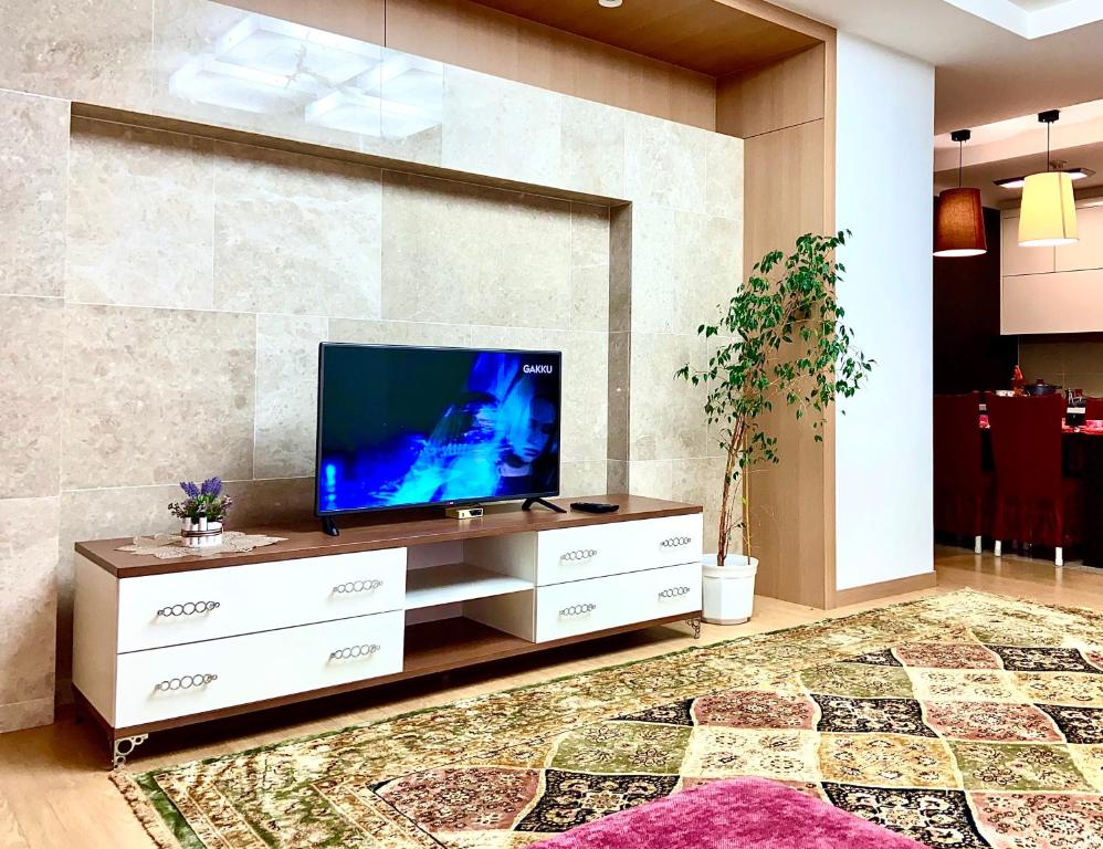 a living room with a flat screen tv on a cabinet at Хайвилл Астана in Astana