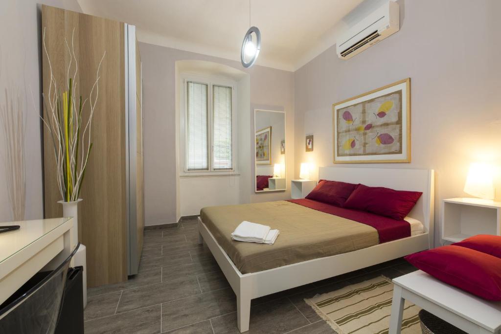 um quarto com uma cama com almofadas vermelhas em Affittacamere Le Farfalle em La Spezia