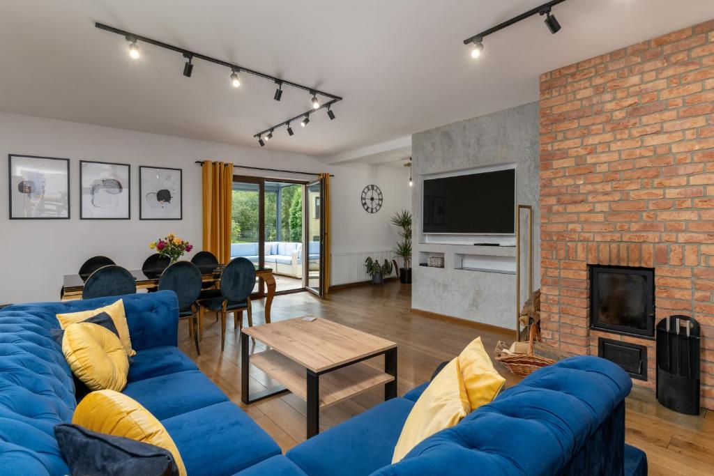 a living room with a blue couch and a fireplace at Apartamenty City Life Dom nad Zaporą w Wapienicy z Jacuzzi, balia in Bielsko-Biała